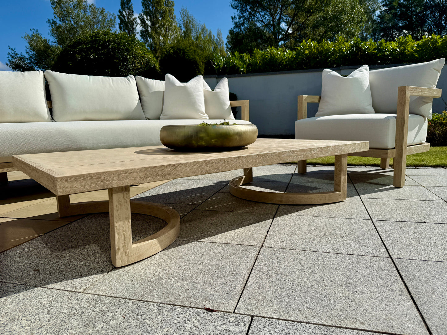 Hamilton Teak coffee table lifestyle shot in garden patio setting low angle showing legs